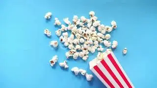 Popcorn Spilling From a Container on Blue Background | Stock Footage - Envato elements