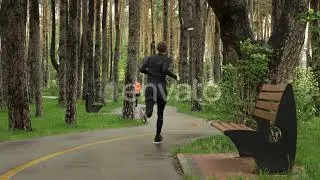 People running in the park on rainy day. Man and woman jogging in the park | Stock Footage - Env...
